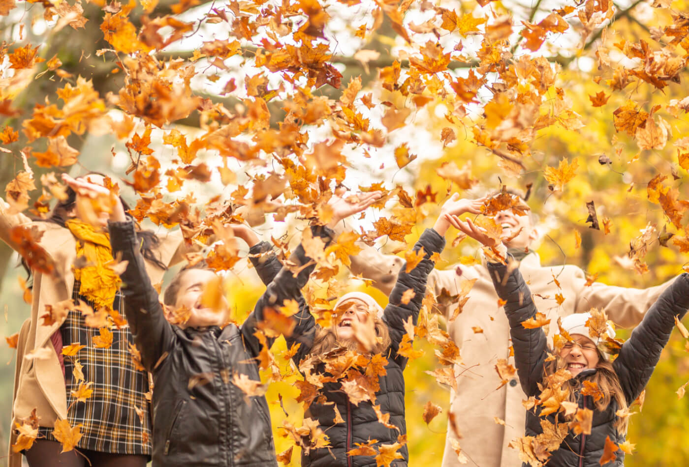 family-throwing-leaves-in-october-half-term-in-cornwall