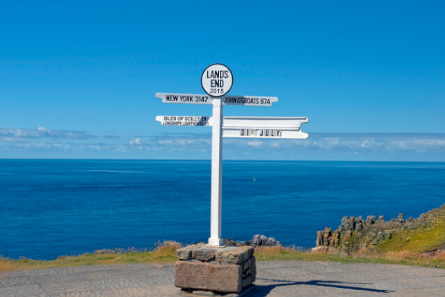 View of Land's End sign in Cornwall, England, with the sea in the background