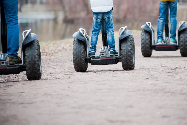Three Segways being driven a long a track
