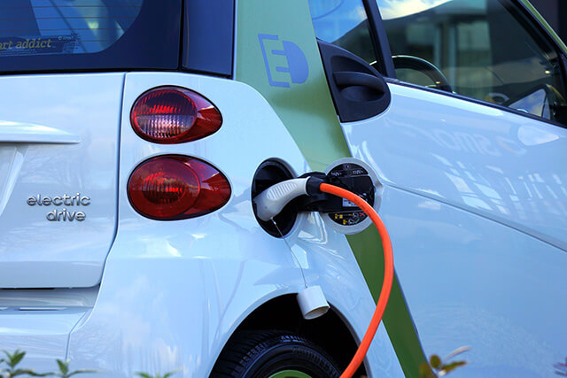 Car being charged with electric charging point.