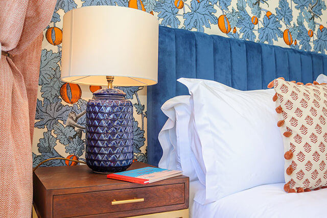 A headboard, lamp, side table and cushions at Sea Two Seas holiday cottage, Cape Cornwall