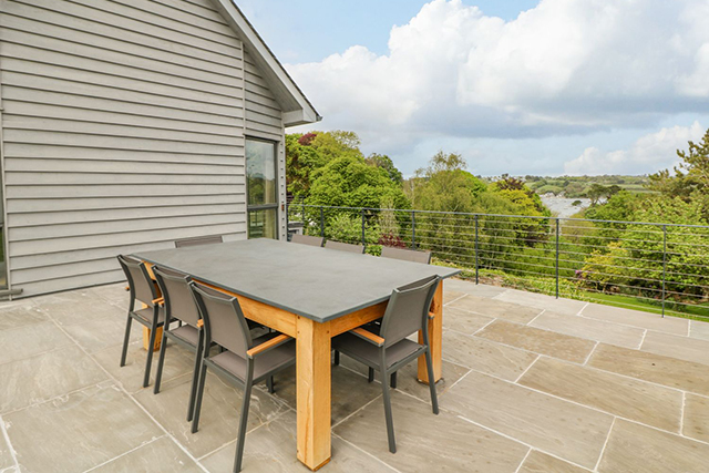 furnishing a holiday let - outdoor patio with table and chairs overlooking the water.