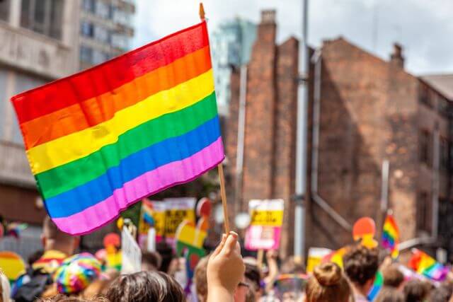 Pride flag amidst a crowd at a Pride event.