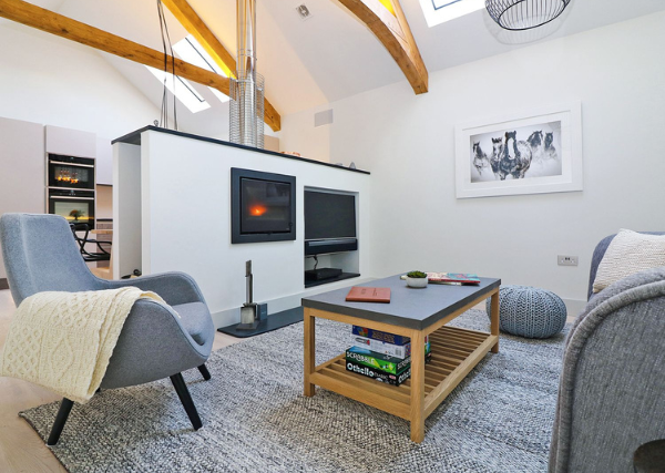 Choosing a Holiday Letting Agency in Cornwall | Lounge with wood burner at the Stable, Boskensoe Barns