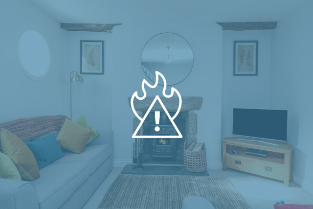 Fire hazard icon overlaid on an interior shot of a Cornish Cottage Holidays property