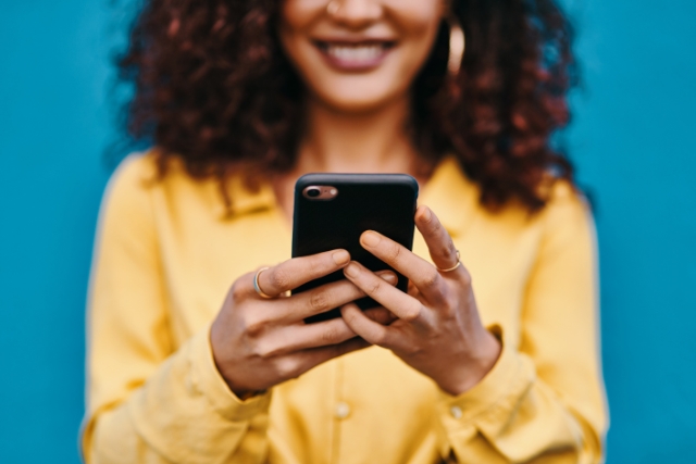  Tips on Holiday Let Advertising and Marketing | Woman in yellow top holding mobile phone