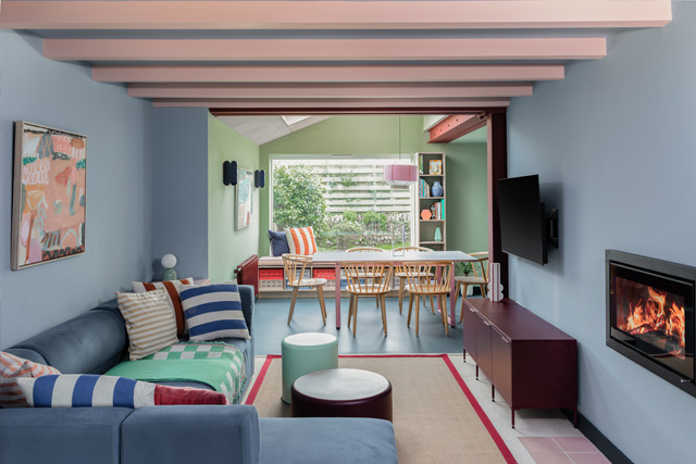 A lounge with light blue walls and a fireplace, designed by Studio Far West